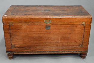 A late 19th century part brass inlaid camphorwood campaign trunk, raised on turned feet, brass