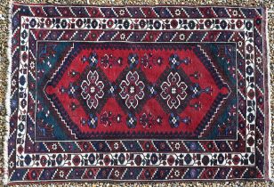 A Turkish Dosemealti rug with three diamond medallions on red ground, blue and gream borders, 194