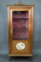 A Napoleon III style giltwood three quarter glazed display cabinet surmounted by a ribbon bow