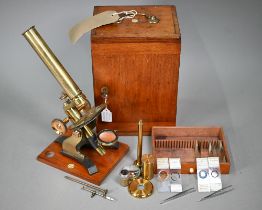 A vintage brass travelling microscope in box, with detachable platform lenses, slides etc by