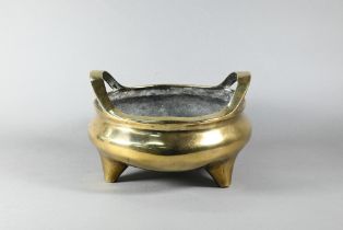 A large 19th century Chinese bronze tripod censer, compressed globular form with loop handles