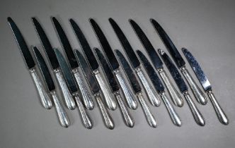 A set of eight each table knives and cheese knives with loaded silver handles, Terry Shaverin,