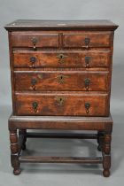 A diminutive George II country oak chest on stand, with two short over three long graduated drawers,