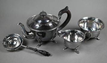 A silver three-piece tea service of cauldron form with ebonised handle and finial, on hoof feet,