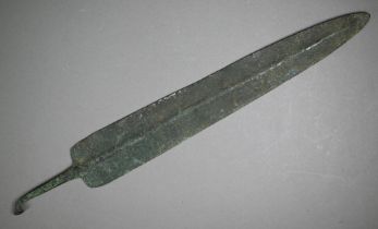 A Bronze Age shortsword blade of broad fin form with raised midrib, the tang with wrought turn-