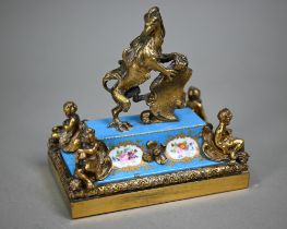 A French gilt brass desk-ornament, cast with a heraldic gryphen supporting a shield, on a (probably)