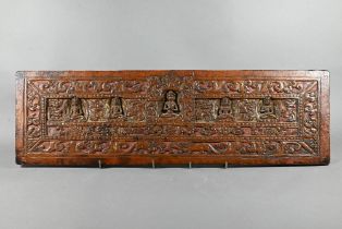 A rectangular hardwood gilded and lacquered panel carved with Buddhist deities in the style of a