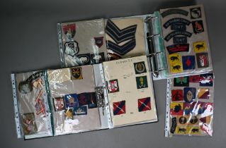 Two folders of British military WWII and other cloth, patch, shoulder titles and other insignia,