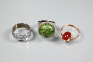 Three various rings - green hardstone set white metal, unmarked yellow metal ring set oval
