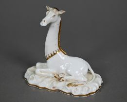 A Victorian china seated giraffe, in the manner of Grainger's Worcester, on naturalistic base, 11.