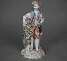 An 18th century Derby porcelain figure of a young man in floral-painted breeches, 24 cm (restored)