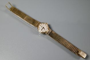 A ladies 9ct gold Omega wristwatch, the dial with baton markers, the integrated graduating bar strap