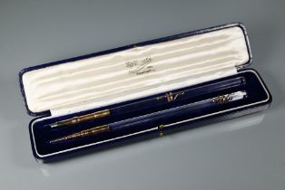 A cased set comprising a dip pen and propelling pencil, each with rose metal fittings, faceted glass