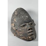 A 20th century stained and carved wood African tribal helmet mask, 32 cm