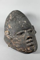 A 20th century stained and carved wood African tribal helmet mask, 32 cm