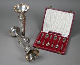 A cased set of six silver coffee spoons with ornate handles, maker HCD, London 1953, 1.4oz, to/w a