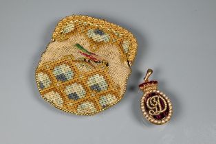 A dark red enamel locket with pearl set border and monogram below a pearl set and red enamel