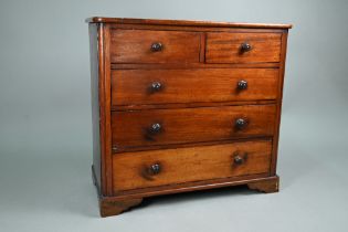An old miniature mahogany chest of two short over three long graduated drawers, with turned pulls,