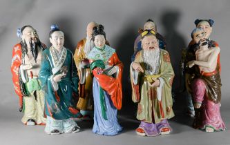 A harlequin set of eight Chinese 20th century polychrome glazed figures, six of the eight Daoist