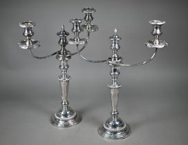 A pair of plated on copper baluster candlesticks with associated detachable twin-branch candelabra