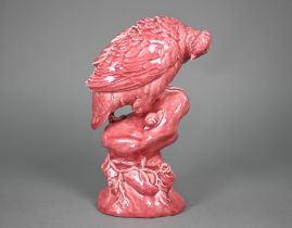 A Minton pink majolica partridge perched on a rock, inspecting a snail, 33 cm high (c 1900)