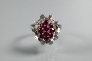 A vintage cluster ring in the form of a flower set with rubies, size Q, 2cm diam