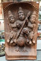 An Indian high-relief carved hardwood panel depicting Karkikeya (Hindu God of War) and his two