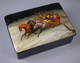 A Russian lacquered papier maché box, the hinged cover painted with a troika on a snowy road, 15