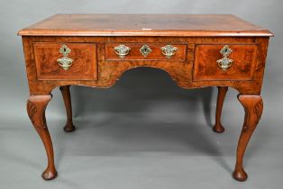 A Georgian style cross and feather-banded quarter veneered walnut side table with three drawers