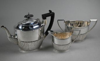 A silver tea service of half-reeded oval form with composite handle and finial, Walker & Hall,
