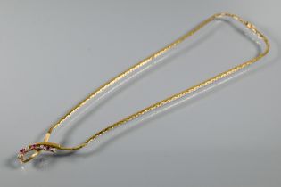 A 9ct yellow gold necklace of flat triangular links with central ribbon twist set rubies and