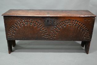 An English oak Commonwealth period six plank coffer, the front fully carved with twin lunettes,