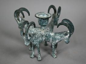 A verdigris-patinated candlestick supported by four goats, in the antique manner, 11 cm high