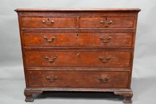 A George III cross-banded oak chest of two short over three long graduated drawers, raised on shaped