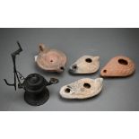 Three antiquity terracotta oil lamps to/w a later example and a reproduction metal lamp (5)