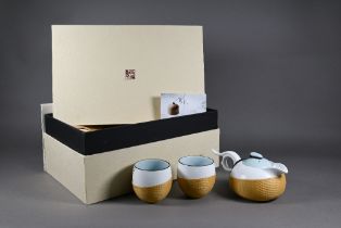 A 1970s Chinese souvenir porcelain and woven bamboo teaset comprising teapot with cover and two