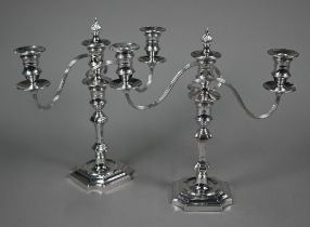 A pair of twin branch candelabra in the early Georgian manner, with twin sconces and flame