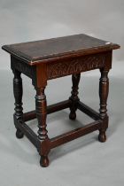 A 17th century style oak joint stool, the single plank seat over a lunette carved frieze, 45 cm x 27