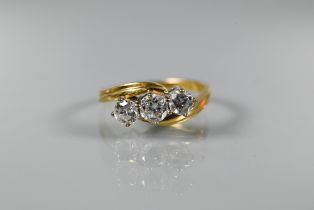 A diamond ring, the three brilliant cut diamonds in 18ct yellow gold scroll setting, approx 0.75