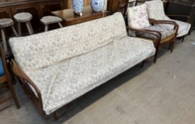 A mid 20th century teak three piece suite comprising a bed settee and two armchairs,