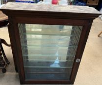 A wall mounted display cabinet with a moulded cornice above a single glazed door