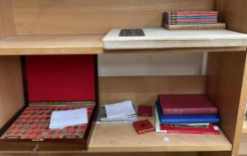 A coin cabinet together with assorted coins and books,