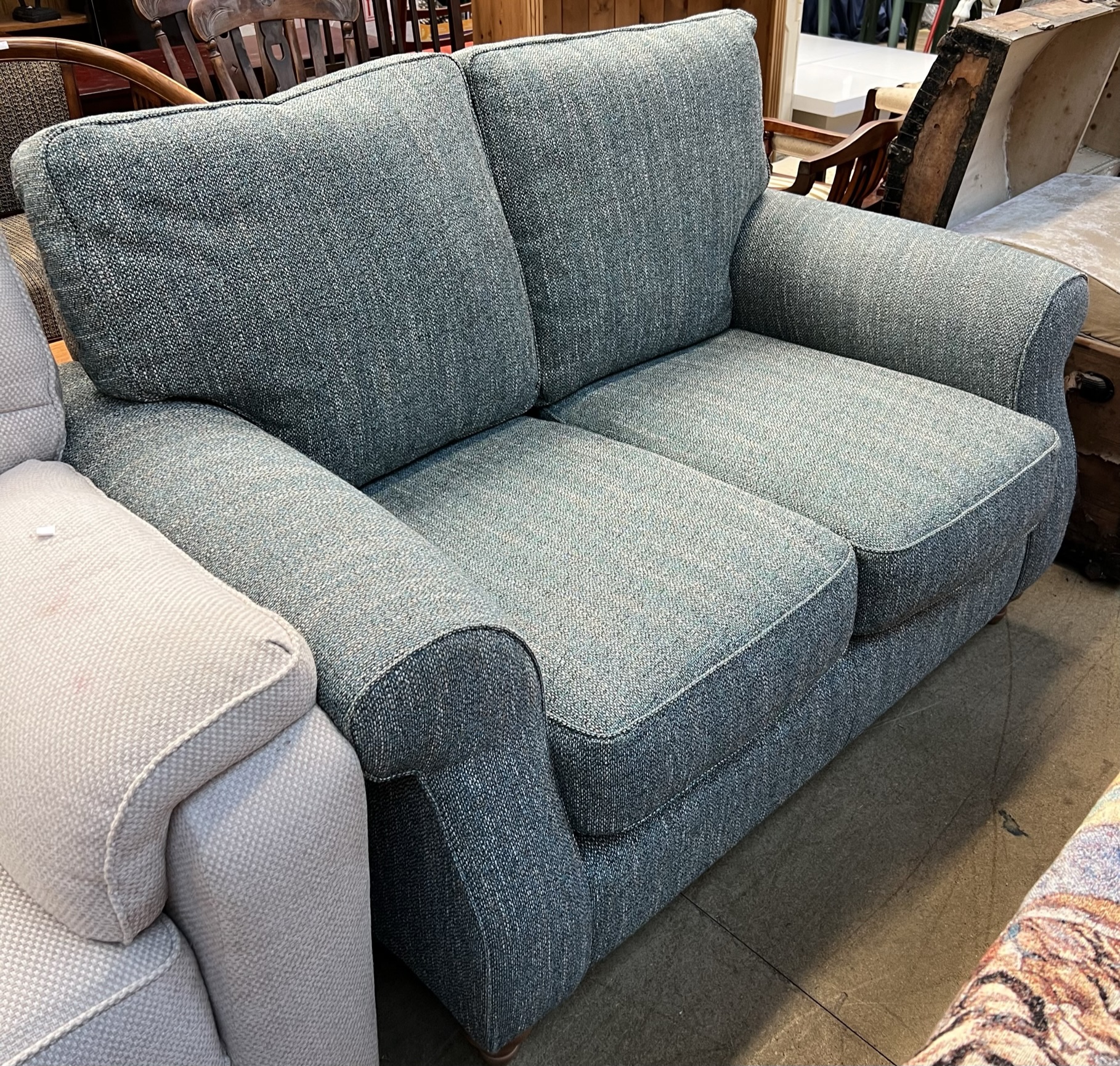 A John Lewis two seater settee in green mottled fabric on turned legs