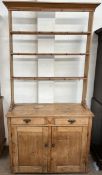 A Victorian pine dresser, the open rack with a moulded cornice above three shelves,