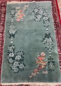 A Chinese rug, with a green ground decorated with flowers and leaves ,