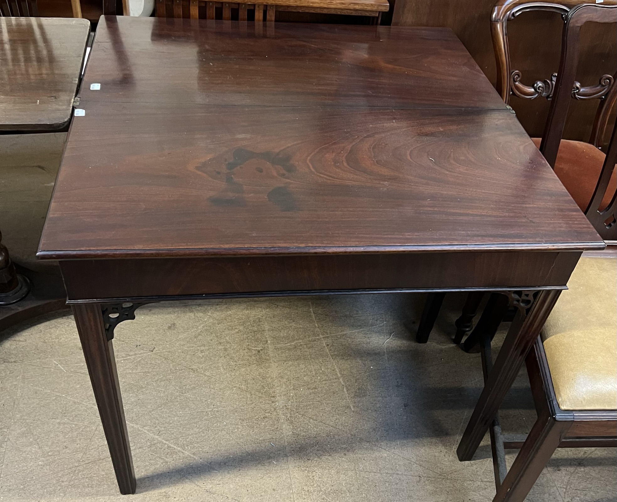 A 19th century mahogany tea table with a rectangular foldover top on square legs