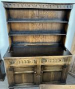 A 20th century oak dresser, with a moulded cornice above two shelves,