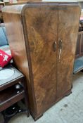 A 20th century walnut wardrobe, with two doors, the interior with hanging space and shelves,