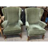 A pair of Parker Knoll upholstered wing back arm chairs on cabriole legs and pad feet