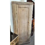 A 19th century pine standing corner cupboard, with a moulded cornice above a single panelled door,